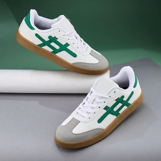 white leather sneakers with grey suede toe caps, emerald green side branding, and tan gum rubber soles