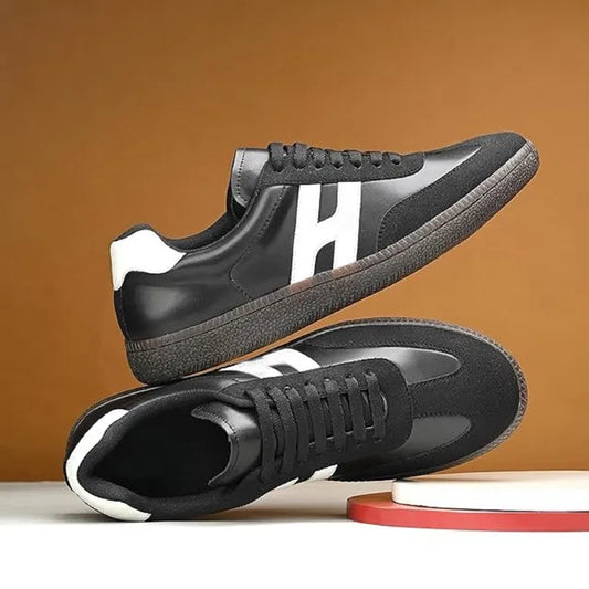 black and white men's casual sneakers with a textured gum sole and a bold white 'H' logo on the side