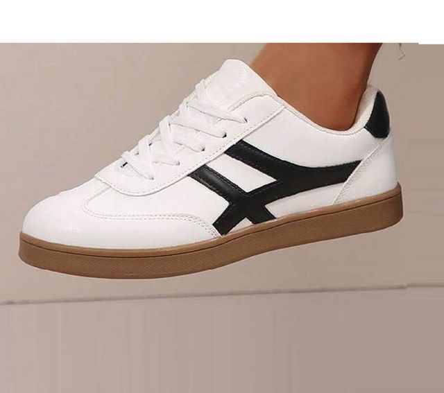 Men's white lifestyle sneakers with a unique black cross-stripe design and a classic brown gum rubber sole for casual styling
