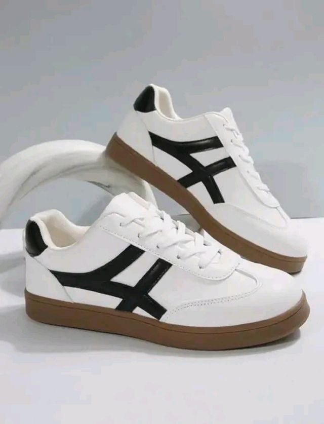 Men's white lifestyle sneakers with a unique black cross-stripe design and a classic brown gum rubber sole for casual styling