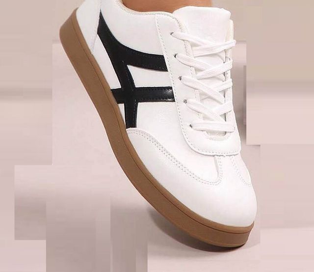 Men's white lifestyle sneakers with a unique black cross-stripe design and a classic brown gum rubber sole for casual styling