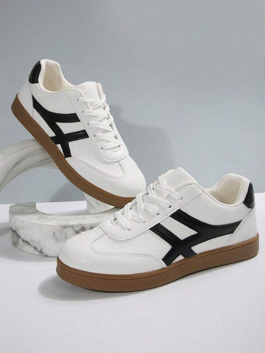 Men's white lifestyle sneakers with a unique black cross-stripe design and a classic brown gum rubber sole for casual styling